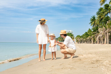 Beach, father and mother and daughter having fun playing and bonding during a beach vacation, family and daughter having fun bonding.