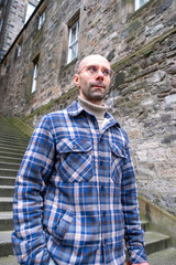 young traveler man explores medieval streets Edinburgh, ancient alleys, discovery archipelago...