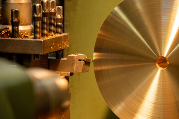Close up scene the lathe machine finish cut the brass material parts by chip insert tool.