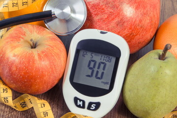 Glucose meter with sugar level, fresh fruits, stethoscope and tape measure. Healthy lifestyle and nutrition during diabetes