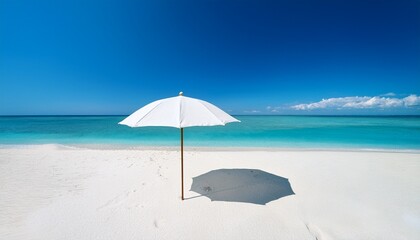 summer vacation background with sun umbrella on white sand beach with turquoise sea under clear sky