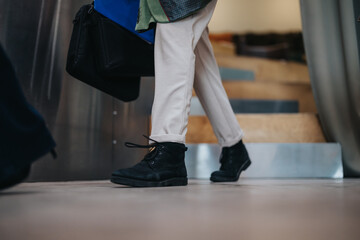 A view focused on a person's legs and footwear, depicting casual movement indoors in a professional...