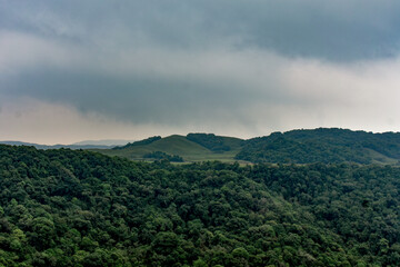 Lush green hills under dramatic cloudy sky in Meghalaya.