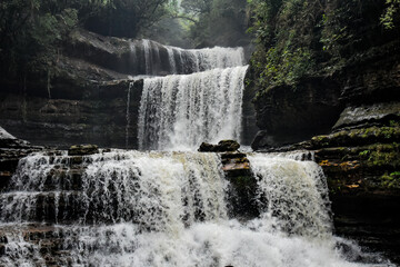 Wei sawdong , a multitiered waterfall cascading down rocky cliffs, surrounded by lush green foliage. A beautiful waterfall in Meghalaya.
