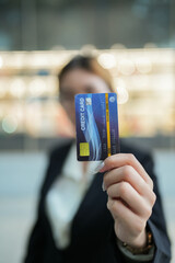 Credit Card Presentation: A focused close-up showcases a credit card, held with intention in front...