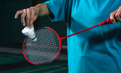 Close up badminton player holding racket and shuttlecock ready to serve