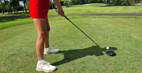 Woman Putting Golf Ball on Green