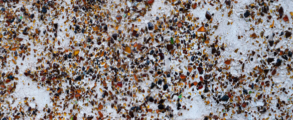 Wall surface with multicolored recycled glass inlays and a rough texture