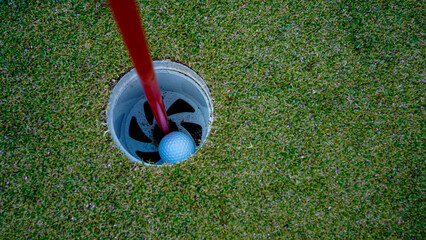 Golf hole on a green grass in the evening golf course with sunshine background.