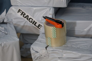 Clear packing tape with utility knife and mailing boxex with sing fragile on one box