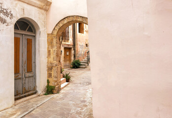 Obraz premium Chania old town architecture. Wooden door and stone arch pastel color walls. Crete island, Greece