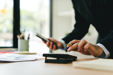 Fototapeta premium Portrait working on smartphone and calculating tax in modern office. Preparing accounting analysis report, real estate investment information, financial and tax system concept.