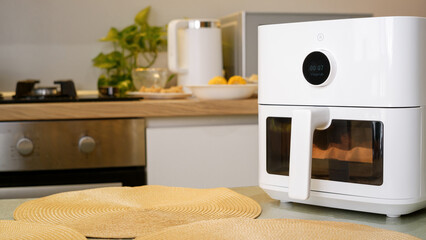 White air fryer cooking food in modern kitchen