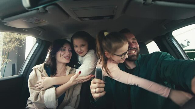 A happy young family gets the keys to their new car at a modern car dealership. The end of a test drive or purchase of a new car.