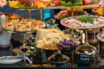A variety of dishes displayed on a restaurant buffet table. The assortment includes diverse...