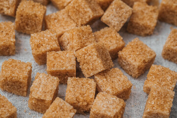 Brown sugar cubes arranged on a textured surface for culinary use and decoration