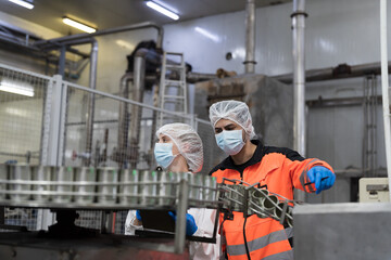 Canned fish factory, seafood manufacturing and food processing. Conveyor belt, production, team of engineer factory. Group of plant engineer checking, maintaining of seafood processing conveyor belts