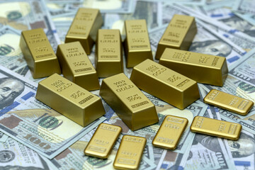 Gold bars are neatly arranged on background of dollar bills, symbolizing wealth and financial security. shiny gold bars contrast with paper currency, highlighting their value