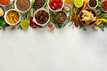 A vibrant assortment of spices and herbs on a gray background, offering a flavorful addition to any...