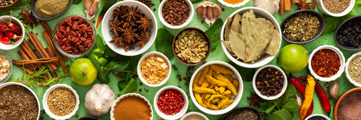 A beautiful collection of colorful spices and herbs, showcasing their natural aromas and vibrant hues on a gentle green background, banner