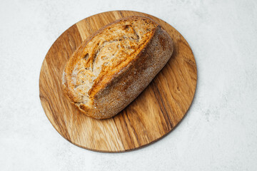 Freshly baked artisan bread rests on a wooden cutting board