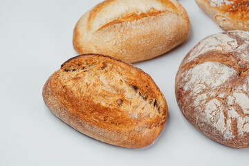 Freshly baked artisan bread loaves displayed on a white surface