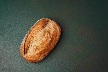Fresh artisan bread loaf on a textured surface ready for slicing