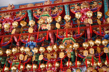 Taiwan June 2, 2025: Golden prayer plaques with red tassels hanging in a Taiwanese temple, symbolizing blessings and wishes from worshippers..