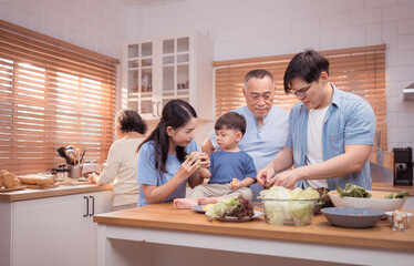 Happy Asian family preparing food together in a bright kitchen,