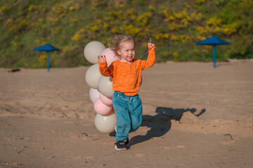 Cute little child on a sandy beach with a beautiful landscape
