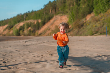 Cute little child on a sandy beach with a beautiful landscape