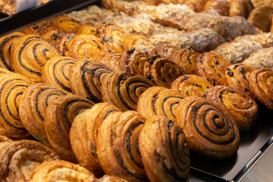 Assorted pastries displayed in a bakery showcase during morning hours