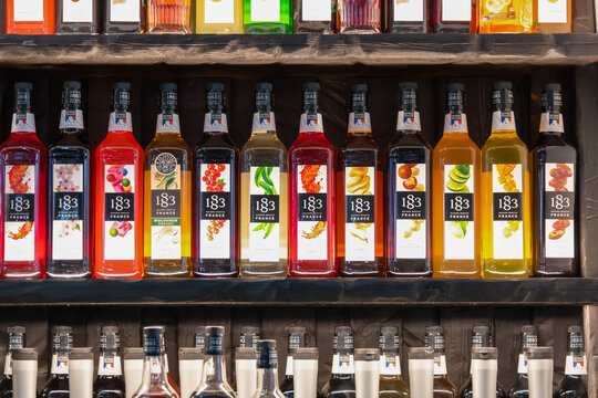 Russia, Moscow - October 07, 2021: Front view of colorful display of flavored 1883 Maison Routin syrups in a bar setting during daytime. Illustrative editorial. Copy space.