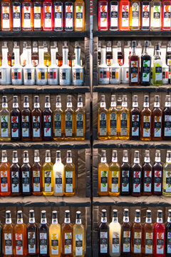 Russia, Moscow - October 07, 2021: Front view of colorful display of flavored 1883 Maison Routin syrups in a bar setting during daytime. Illustrative editorial. Copy space.