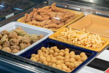 Variety of fried snacks displayed in a food stall during a festival