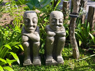 Fototapeta premium Sidemen, Bali, Indonesia – June 1, 2025: Traditional Balinese stone statues resembling human figures in garden serenity