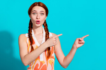 Portrait of lovely young girl impressed point fingers empty space wear dress isolated on turquoise color background