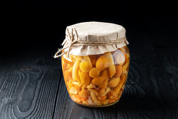 Jar of Pickled Mushrooms on Rustic Wooden Background