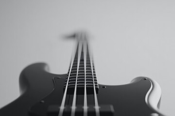 minimalistic view of electric bass guitar against plain background