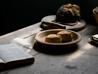 Rustic bread and scones on a wooden table in soft, natural light.