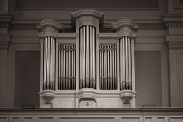 centuries-old pipe organ with gleaming pipes stands in grand dimly lit church