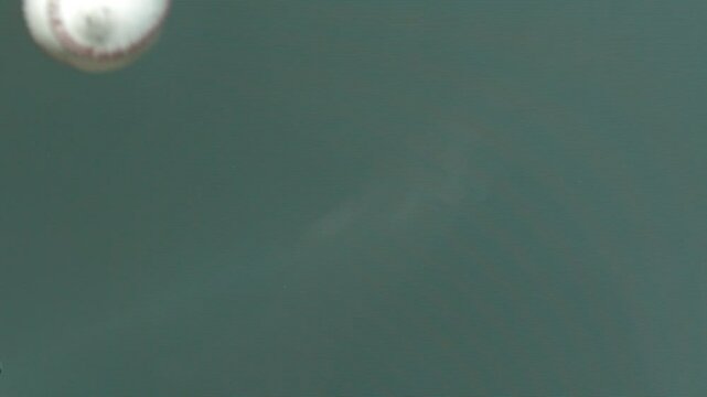 Close up, super slow motion shot of baseball striking flatscreen TV and cracking it