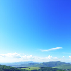 Panoramic view of mountains under a vast blue sky on a bright sunny day