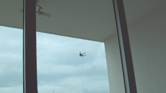 View inside apartment as parachuter falls from skyscraper outside - super slow motion at 1000 FPS