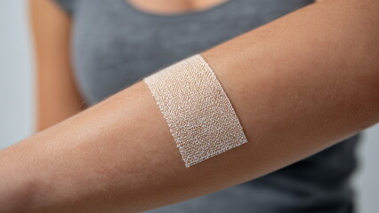 Band aid on an arm, white background.