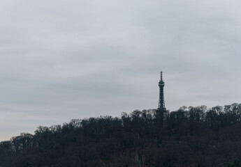 Fototapeta premium rague Petřín Tower silhouetted above forest hill