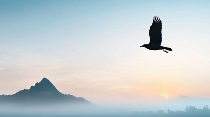 Bird gracefully flying over misty mountain landscape at dawn, with soft sunlight illuminating serene scene and creating tranquil atmosphere