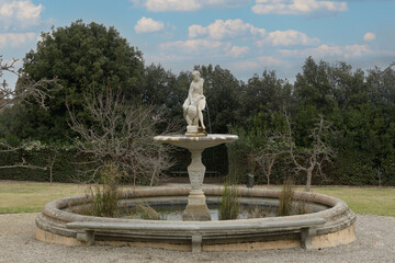 Marble fountain with seated female figure holding water vessel in Boboli Gardens, classical sculpture, Florence, Italy.