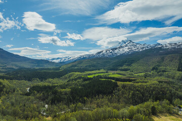 Mountain view near the city of Narvik in Norway. Spring, sun, greenery and snow-capped peaks.