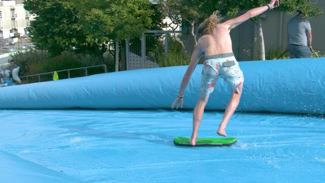 Man attempting to ride board on water slide in the middle of city - super slow motion at 1000 FPS